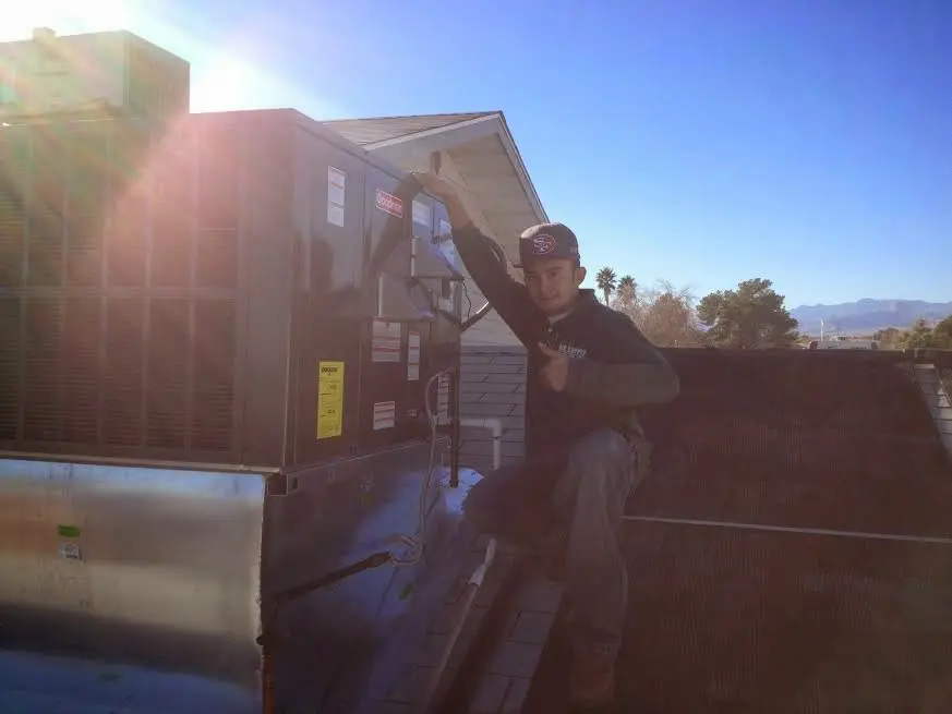 HVAC technician performing HVAC Inspection on a rooftop unit in Enoch